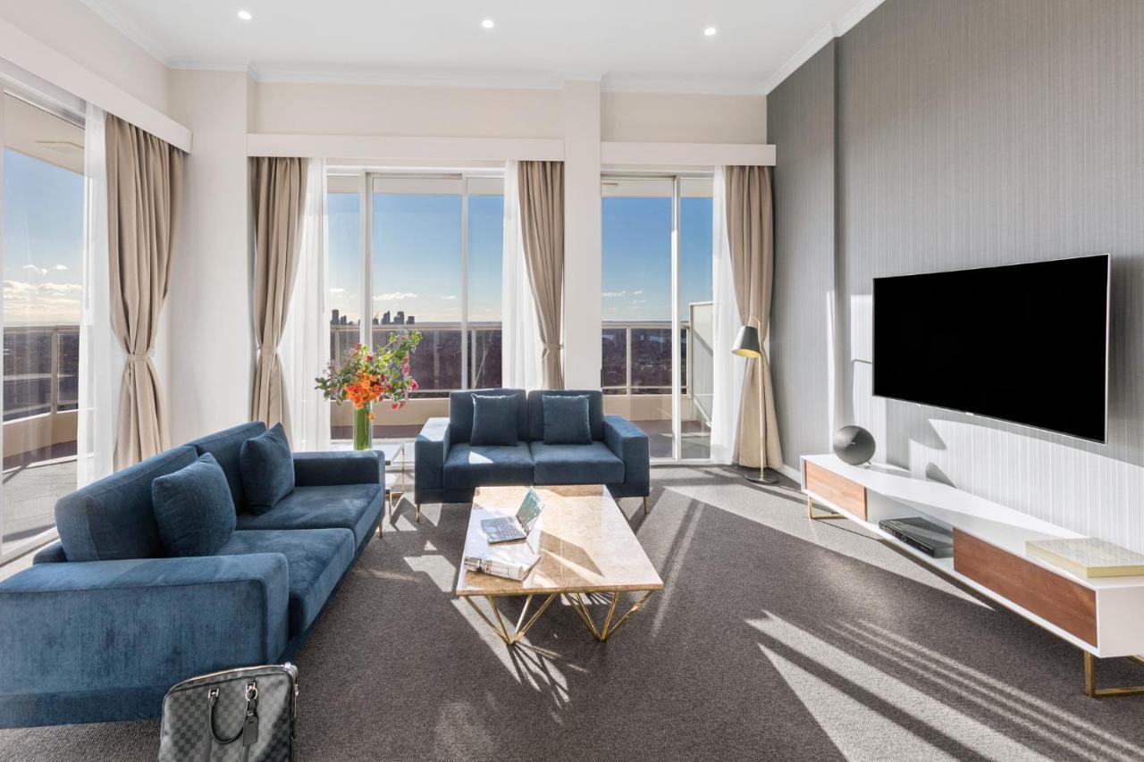 เมอริตัน สวีท บอนดี จังค์ชั่น Hotel ซิดนีย์ ภายนอก รูปภาพ The photo depicts a modern living room with a stylish and contemporary design. It features a cozy seating arrangement with a blue sofa and two matching armchairs. In front of the seating area is a coffee table with a geometric design. The room has la