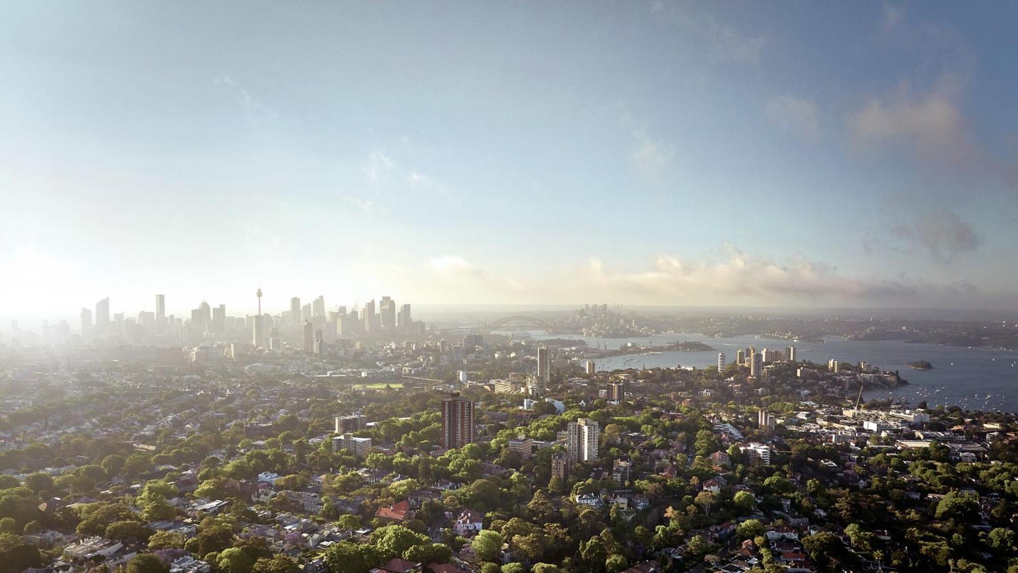 เมอริตัน สวีท บอนดี จังค์ชั่น Hotel ซิดนีย์ ภายนอก รูปภาพ The photo shows a panoramic view of a city skyline, likely taken from a high vantage point. In the foreground, there are lush green trees and buildings, suggesting a suburban area. As the view extends towards the background, tall skyscrapers dominate