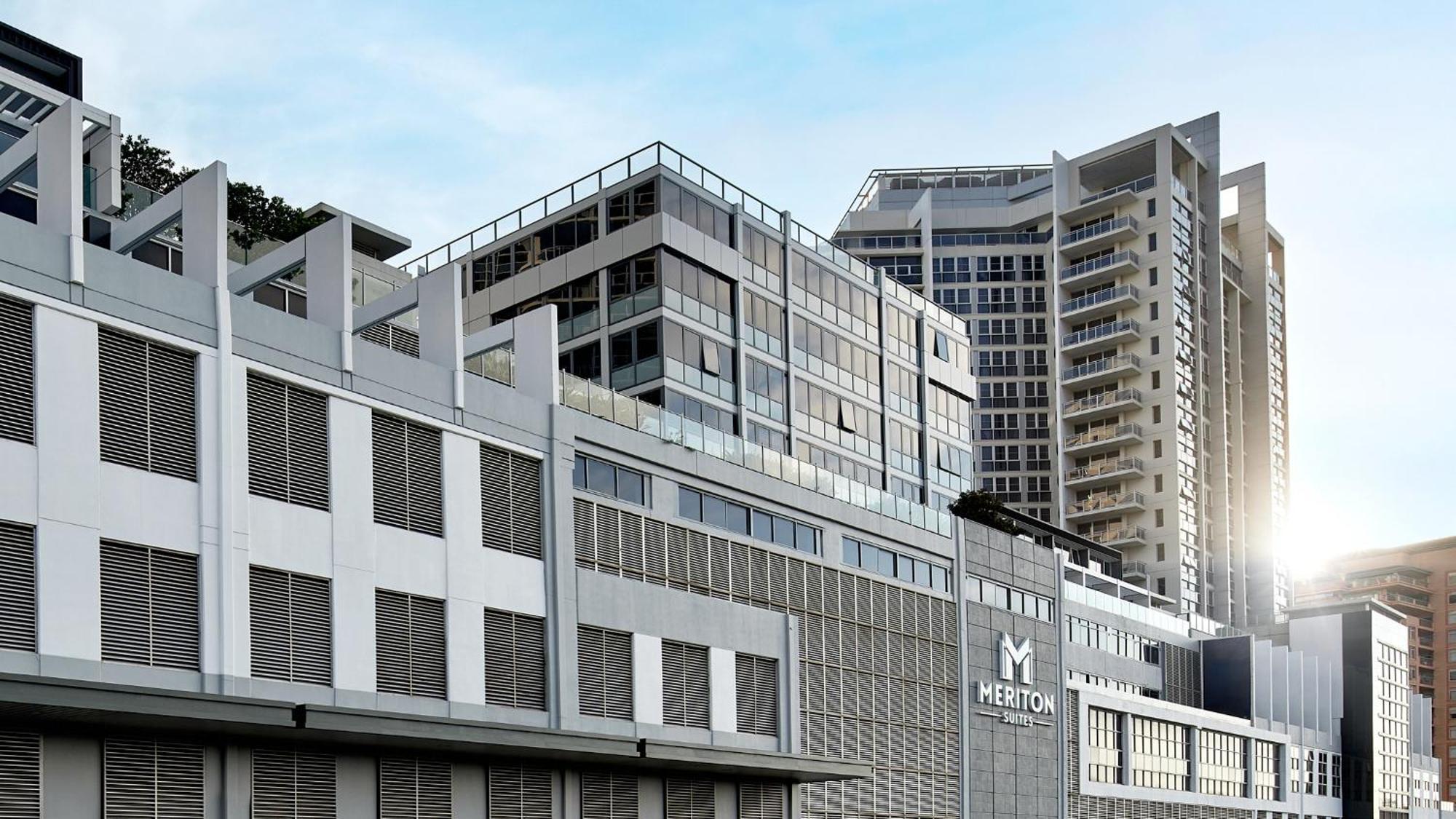 เมอริตัน สวีท บอนดี จังค์ชั่น Hotel ซิดนีย์ ภายนอก รูปภาพ The image shows a modern urban building or complex. The structure features a combination of glass and concrete elements, showcasing contemporary architectural design. The foreground has a lower section that appears to be a podium or base with a textu